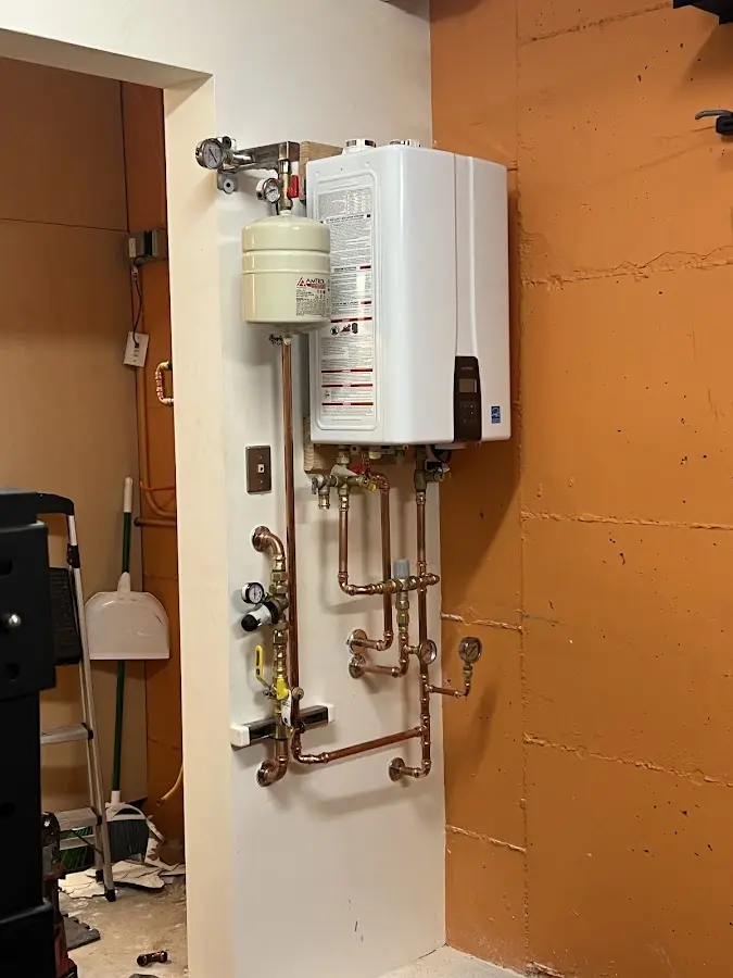 Plumbing technician inspecting water heater connections in Southside